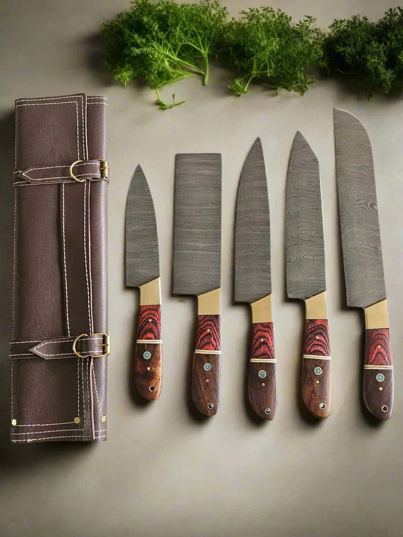 Set of five knives with wooden handles on a gray surface, accompanied by a leather knife roll.
