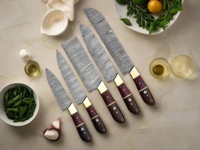 Set of knives with Damascus steel blades and wooden handles on a table with food items.