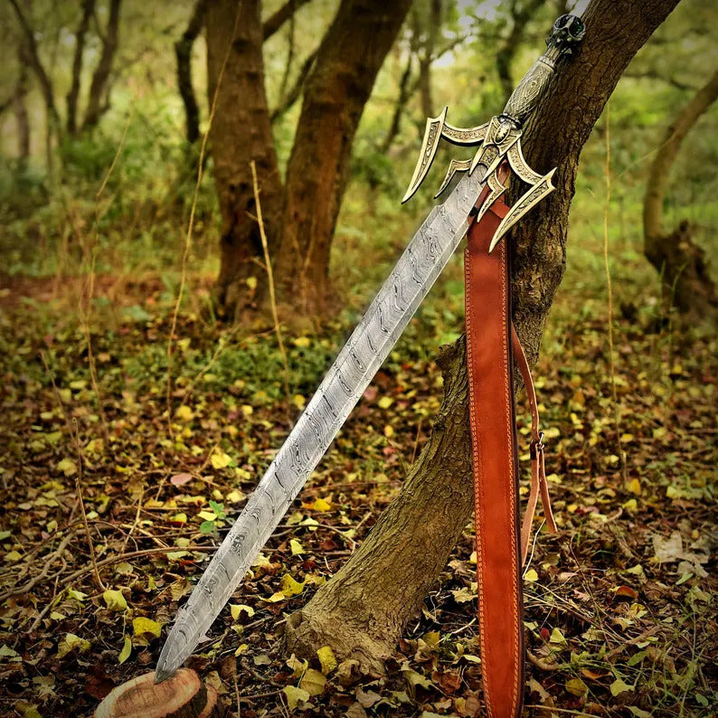 Decorative sword with a red sheath on a tree branch in a forest setting