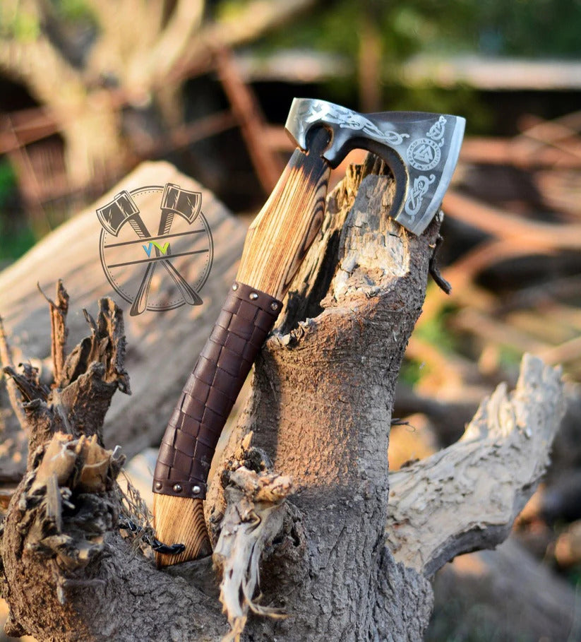 Valknut Viking axe with leather handle on a wooden background