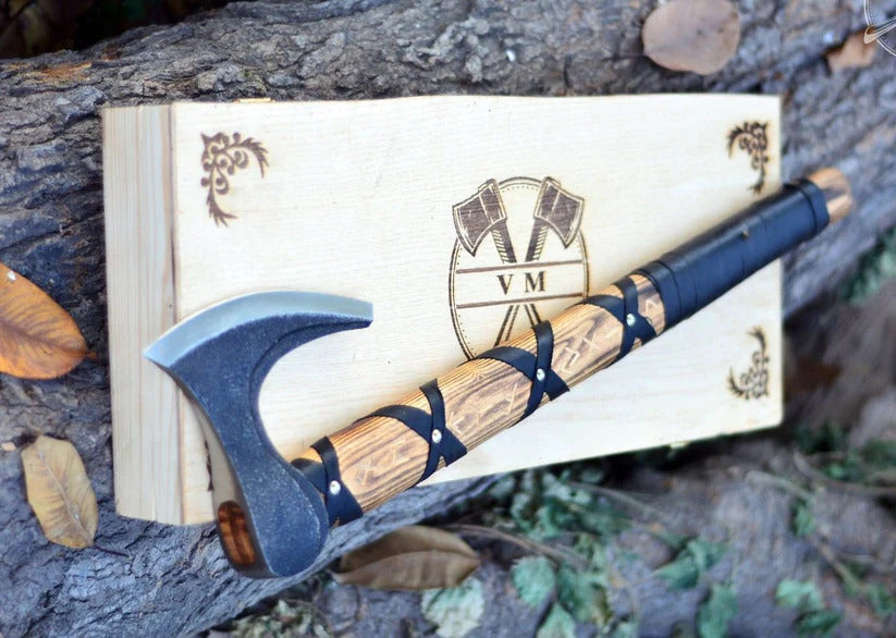 Wooden traditional viking bearded axe with a blue blade on a wooden box