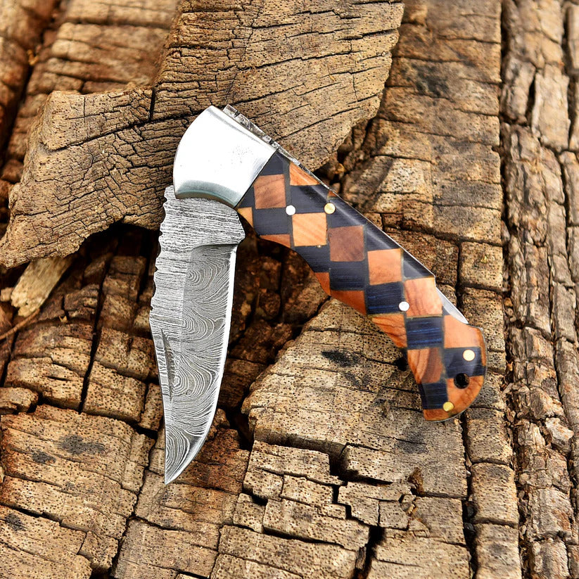 Foldable knife with a checkered wooden handle on a textured wooden background