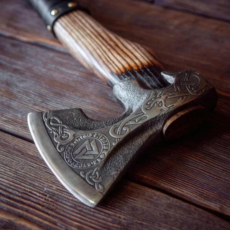 Decorative Hatchet breaded axe with wooden handle on a wooden surface