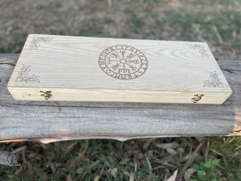 Wooden box with engraved design on a wooden surface