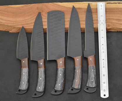 Set of five knives with wooden handles on a dark surface next to a ruler for scale.