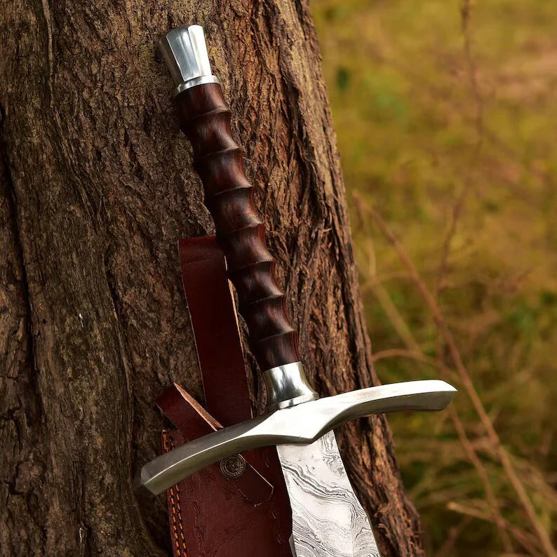 Decorative sword with wooden handle and leather sheath against a tree