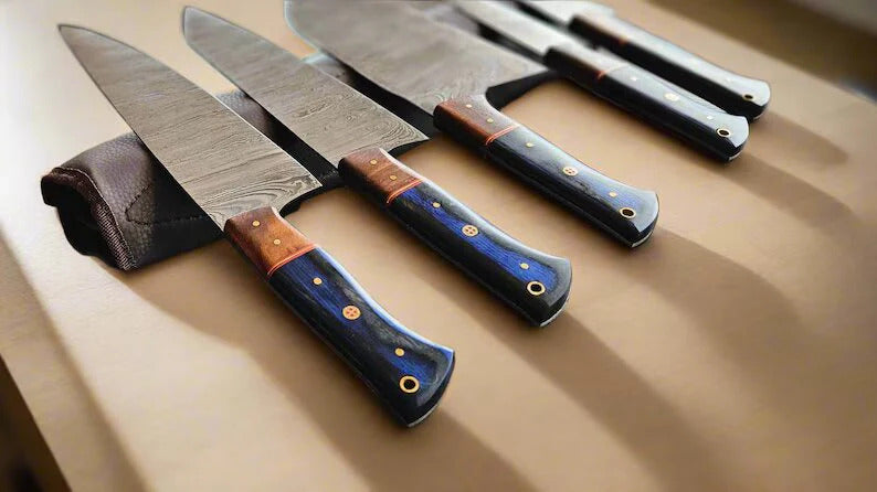 Set of knives with Damascus steel blades and wooden handles on a wooden surface
