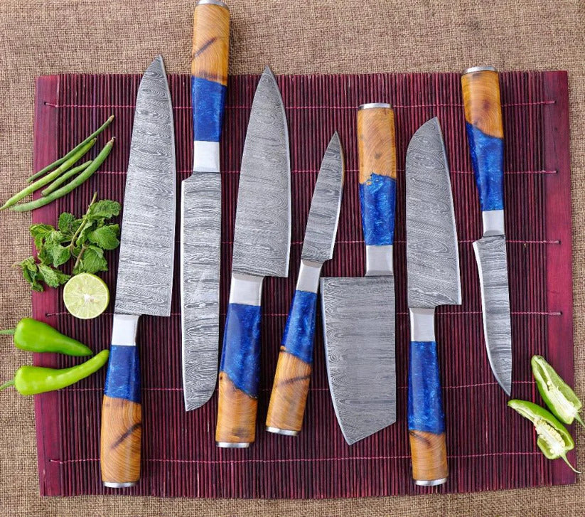 Set of knives with wooden handles on a red mat with vegetables