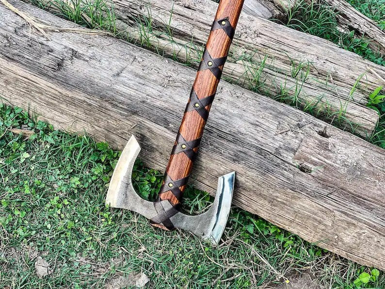 Decorative axe with a wooden handle on a wooden log outdoors