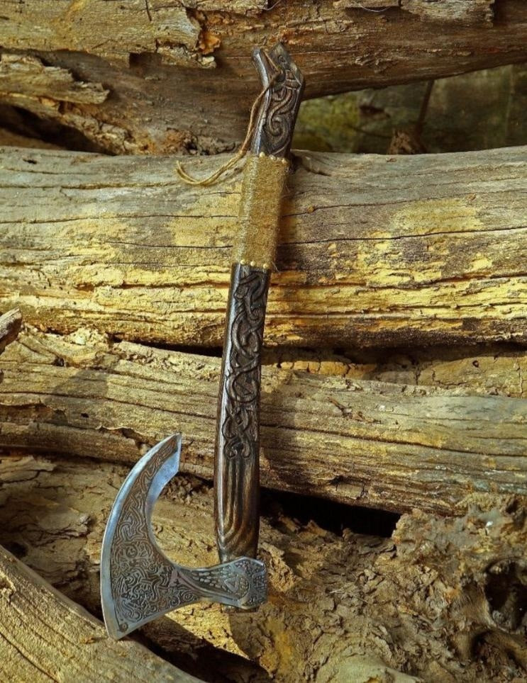 Decorative axe with intricate designs on a wooden background