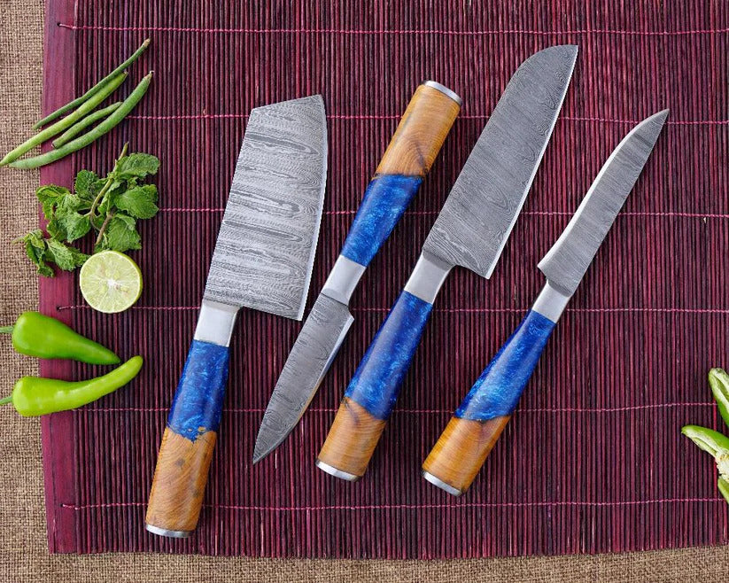 Set of four knives with wooden and blue handles on a red mat with vegetables.