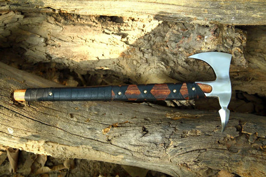 Tomahawk with wooden handle on a wooden surface