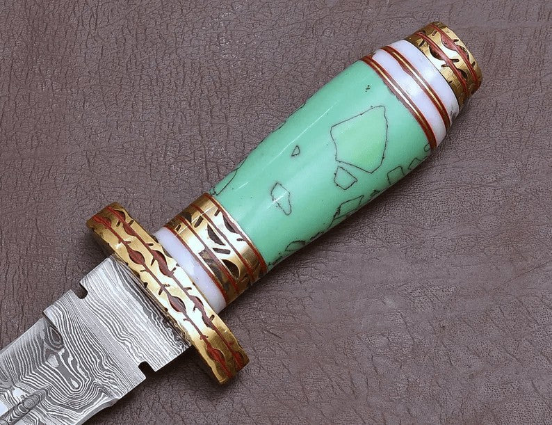 Decorative knife with blue resin handle and gold accents on a brown background