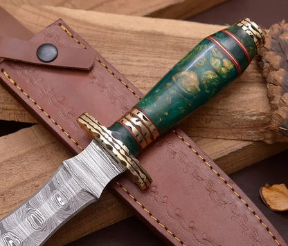 Decorative knife with green handle and gold accents on a brown leather sheath.