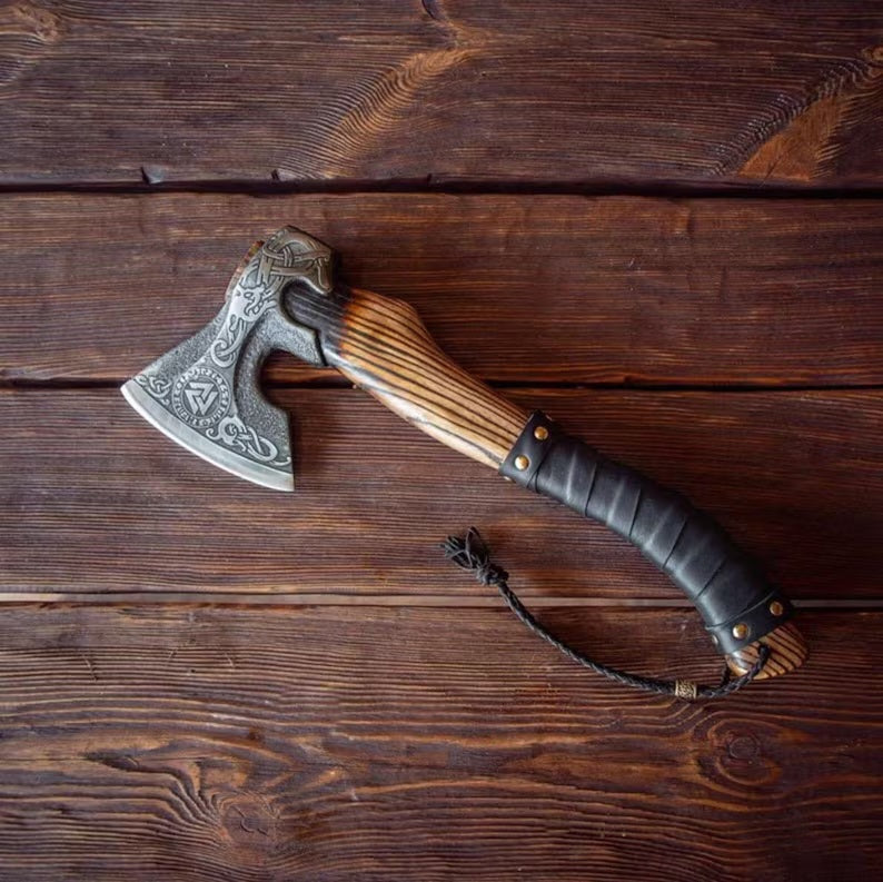 Decorative Hatchet breaded axe with wooden handle and metal head on a wooden surface
