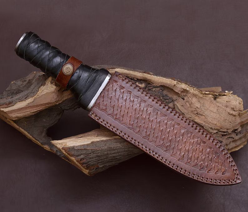 horfinn dagger Knife with a brown leather sheath on a wooden surface