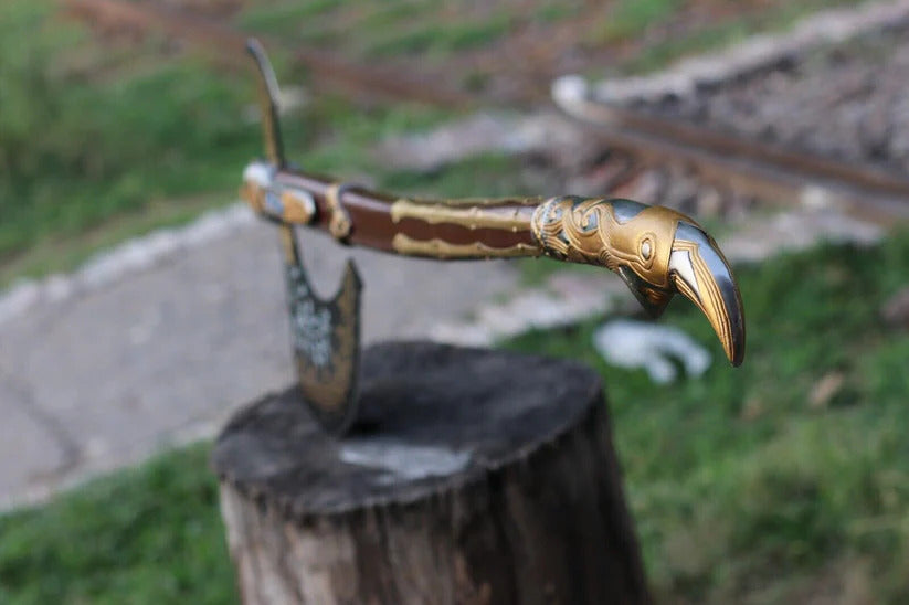 Decorative Kratos Leviathan Viking Axe with gold and brown handle on a wooden stump outdoors
