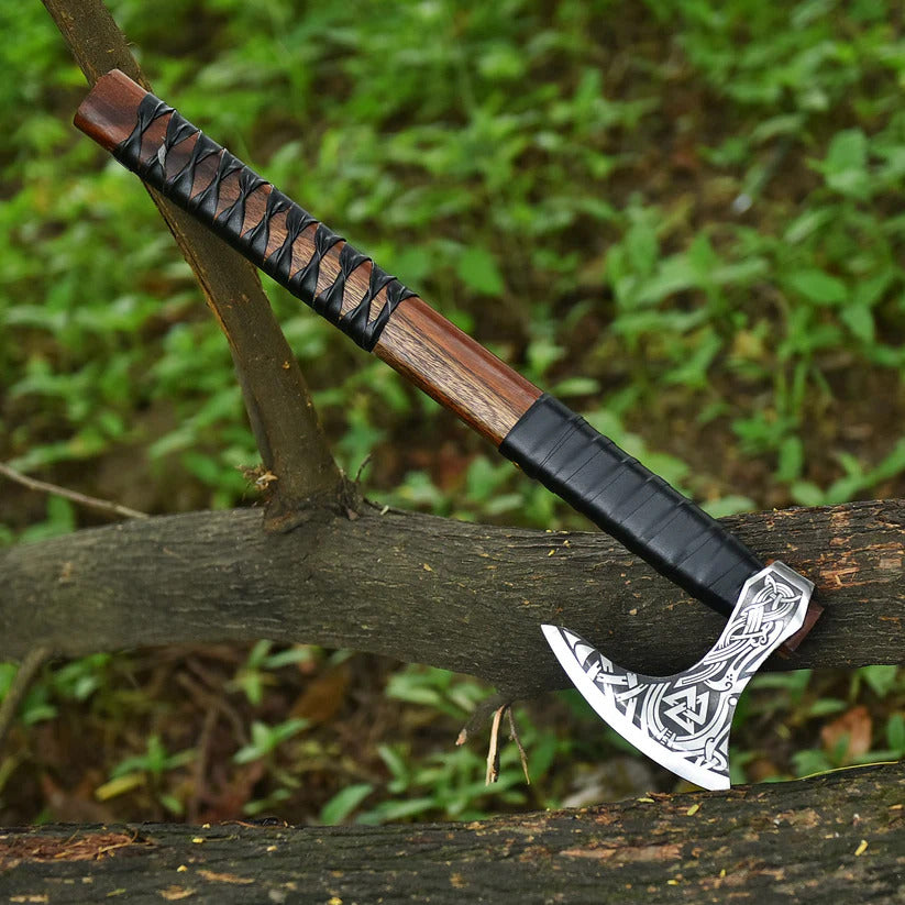 Viking-style axe with decorative blade on a wooden branch