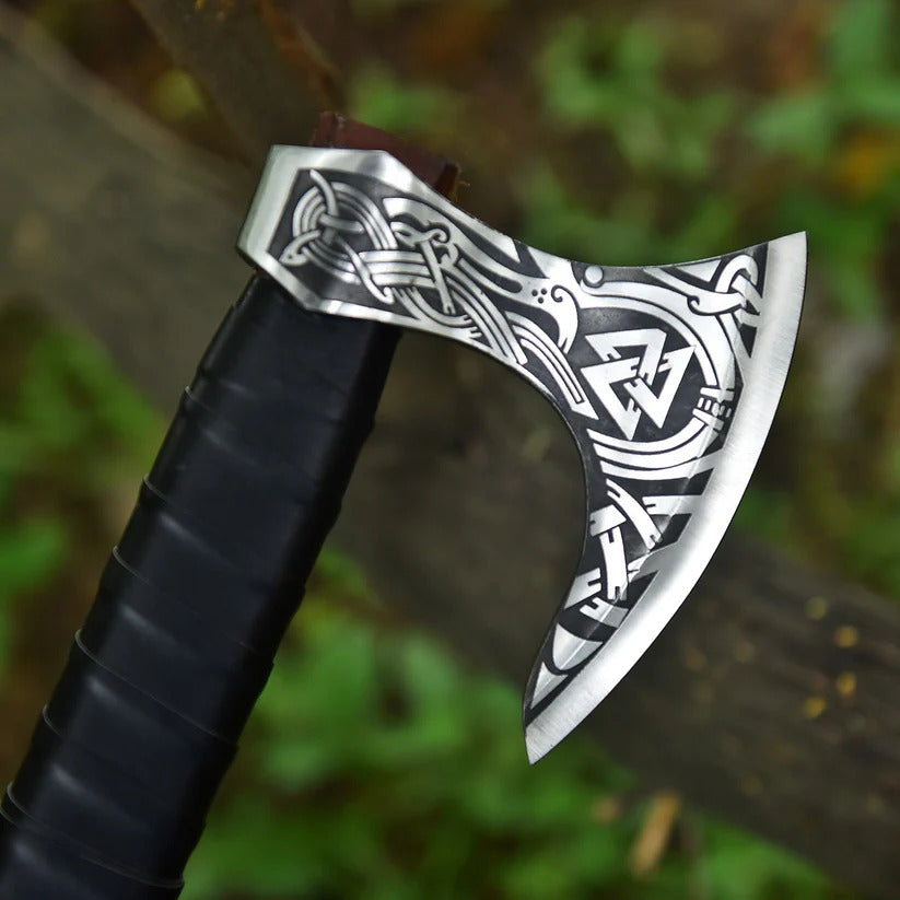 Decorative axe with intricate patterns on a blurred natural background