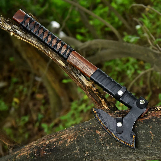 Ragnar Viking Axe with wooden handles and leather straps on a wooden surface with a blurred natural background