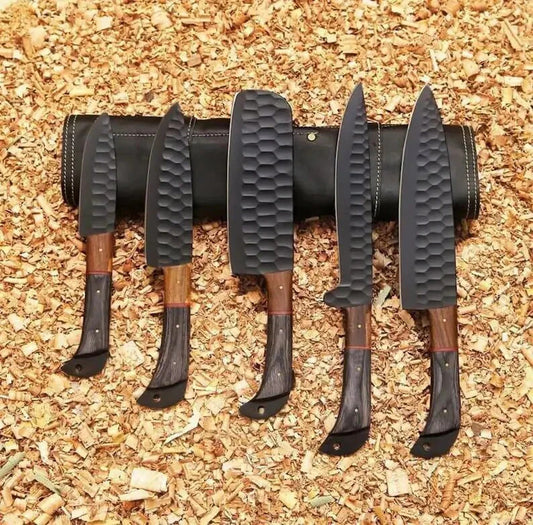 Set of five knives with black handles and wooden blades on a wooden background
