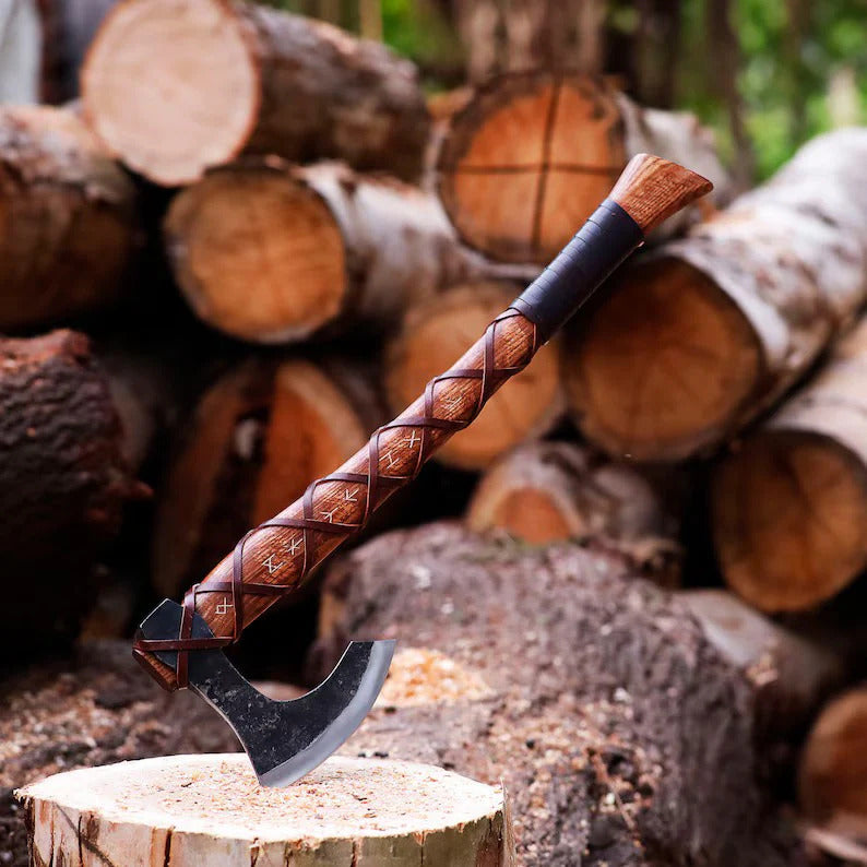 Decorative Authentic Handmade Viking Axe with a wooden handle on a pile of logs