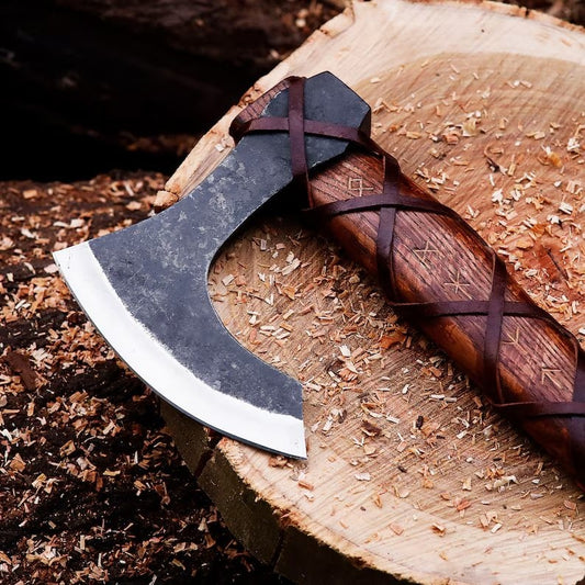 Authentic Handmade Viking Axe with wooden handles on a wooden stump