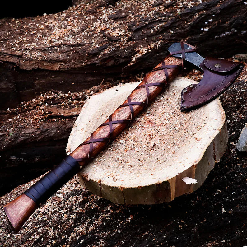 Wooden Authentic Handmade Viking Axe with leather grip on a wooden stump against a natural background