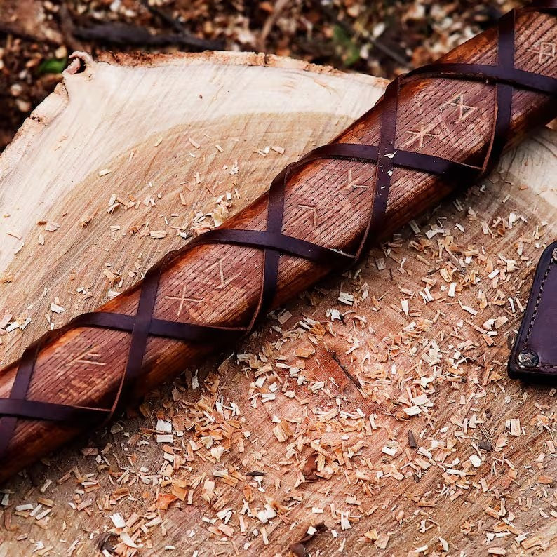 Wooden Authentic Handmade Viking Axe with engraved symbols on a wooden surface