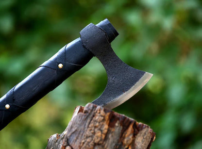 close up of black Ragnar lothbrok  Viking axe head on wood surface