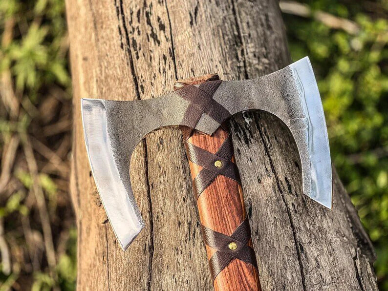 Decorative axe with a wooden handle on a wooden surface