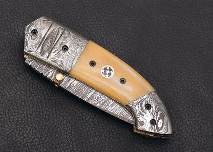 shop cow bone handle folding knife. a beautiful piece that can be used for day to day works. comes with a leather sheath and sharpener and can be customized